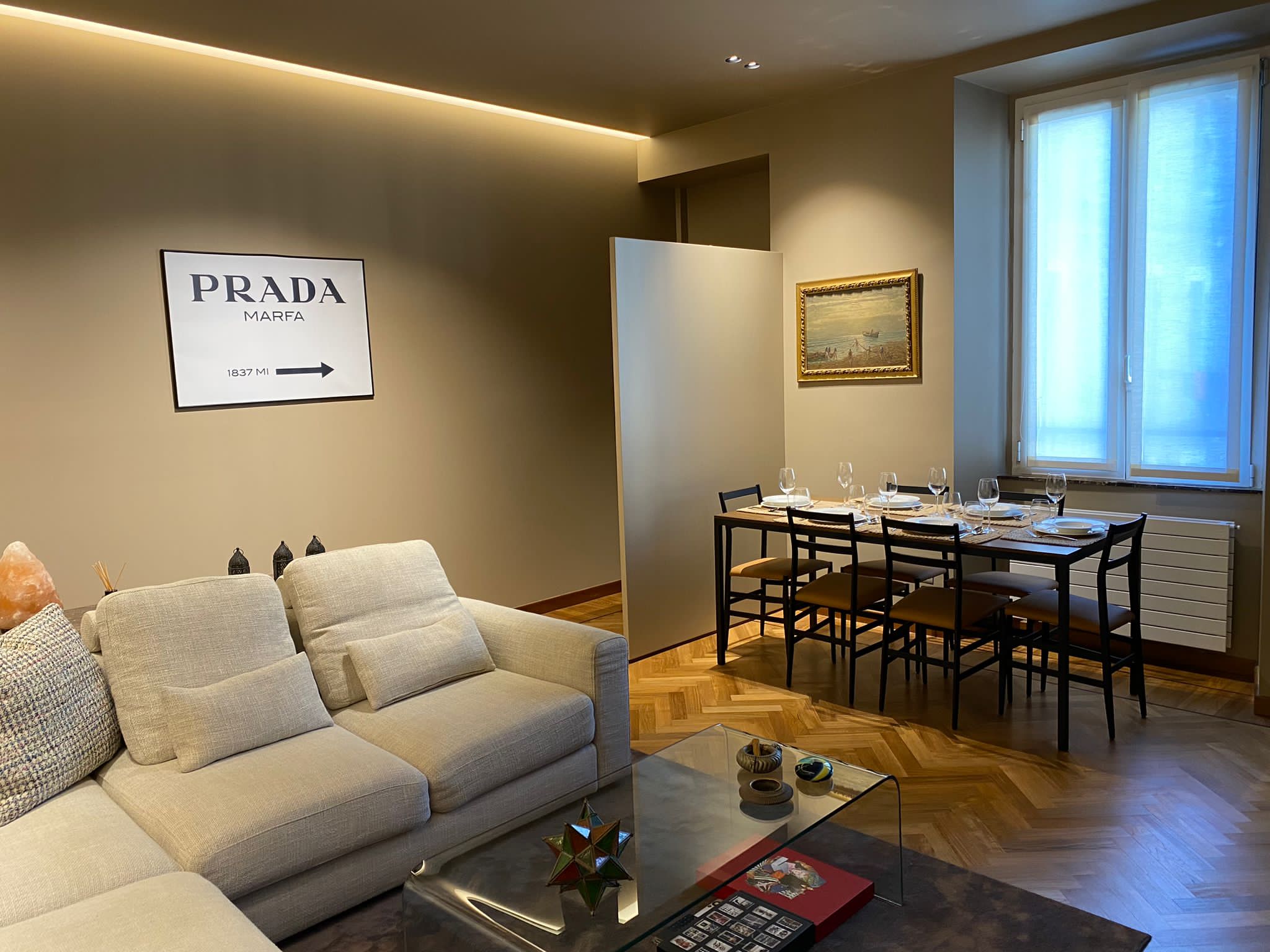Il soggiorno dell'appartamento con la boiserie in noce e la zona living