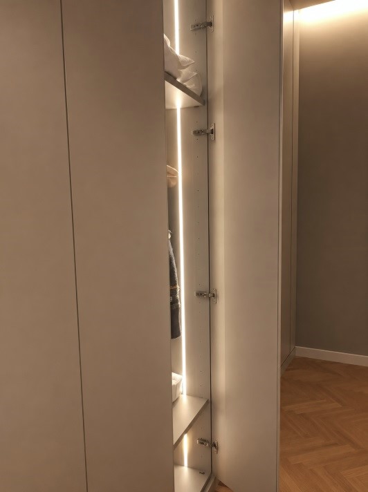 Dettaglio della gola verticale e della strip LED sul fianco dell'armadio