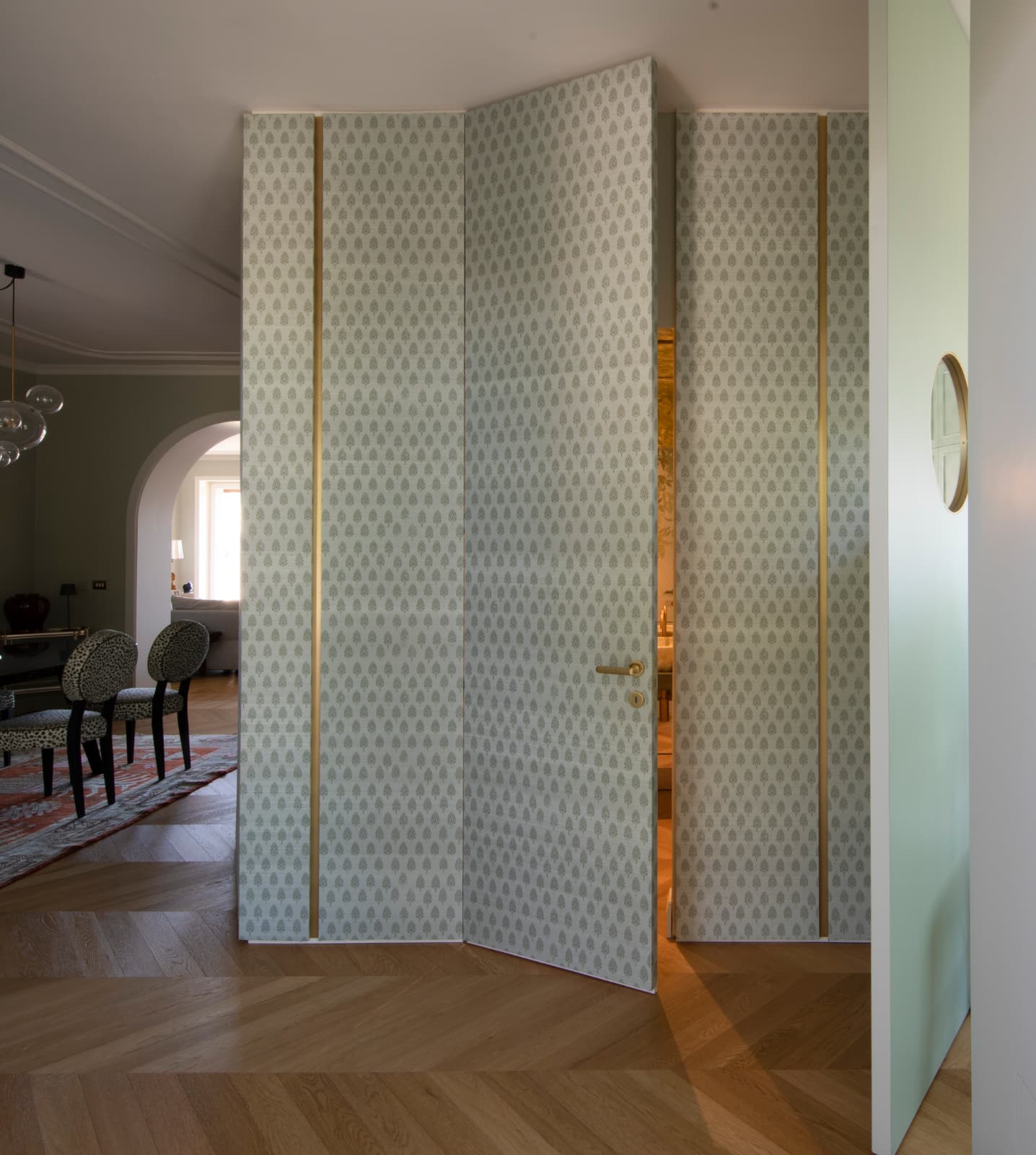 Una porta a tutta altezza della boiserie, socchiusa