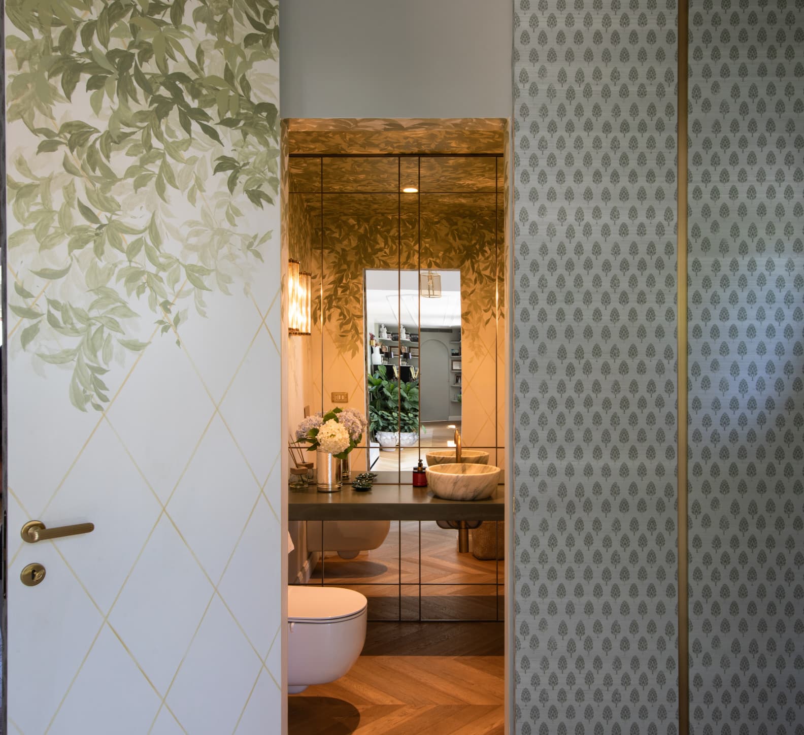Porta aperta tra carta da parati e boiserie, con il bagno sullo sfondo