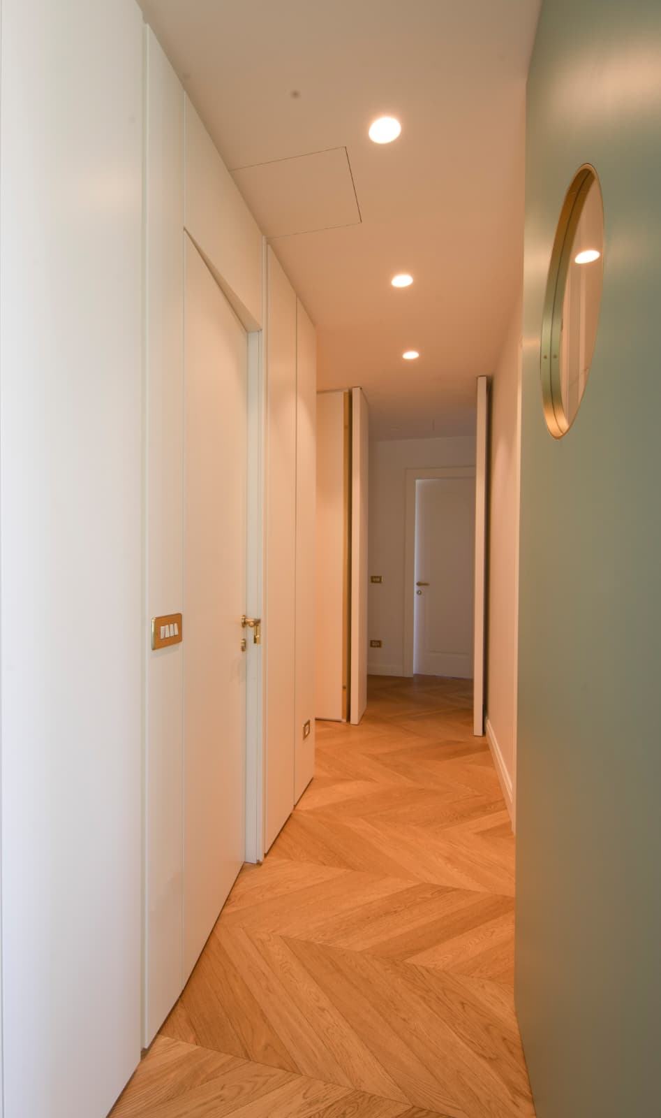 Il corridoio con una porta a tutta altezza socchiusa