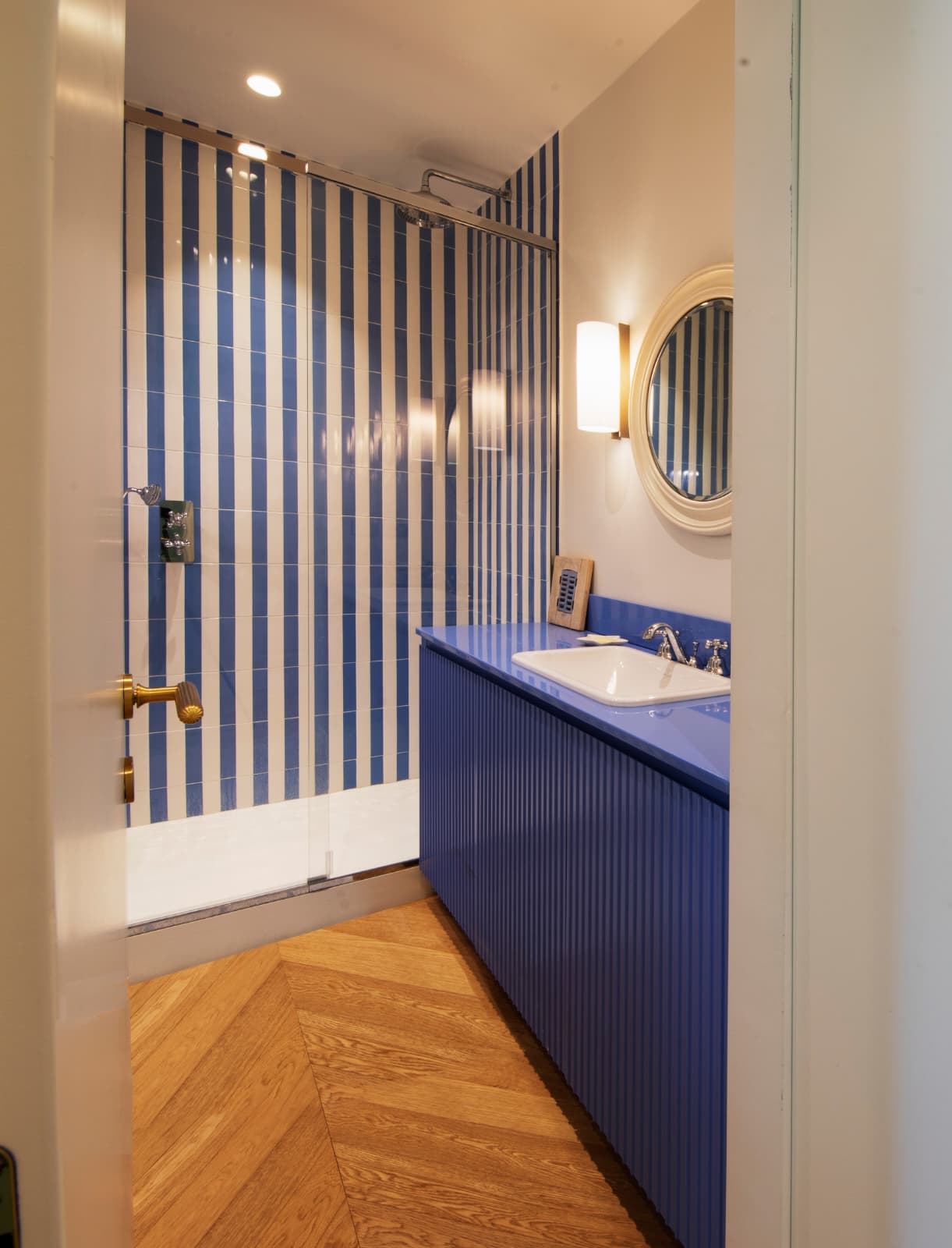 Bagno con mobile lavabo cannettato blu e rivestimento a righe